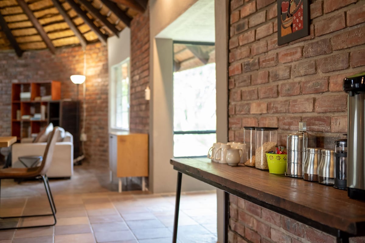 Modern loft interior with exposed brick walls, wooden counter with decorative items, and open living space with furniture